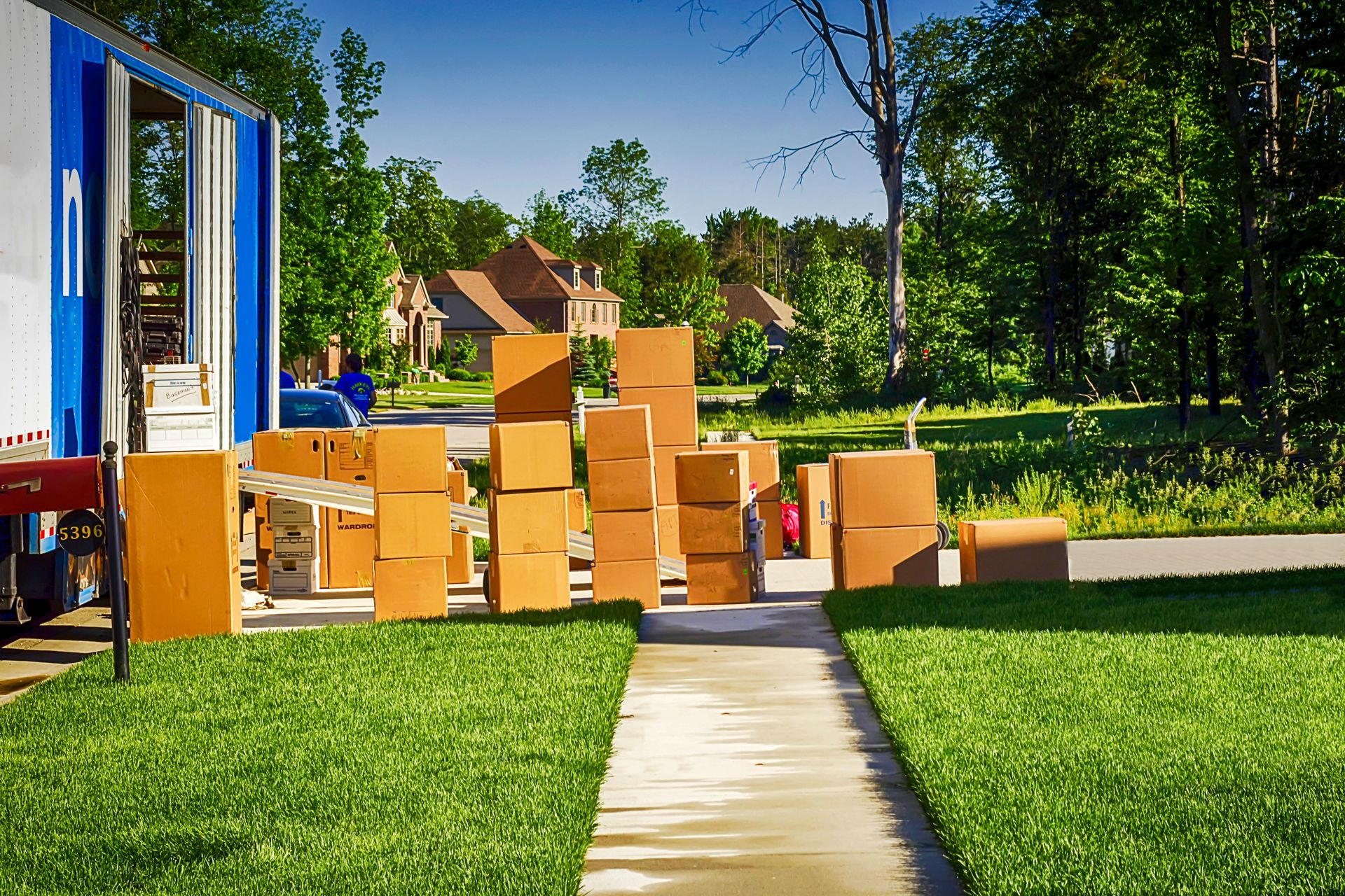 Moving truck and many cardboard boxes on a sunny lawn